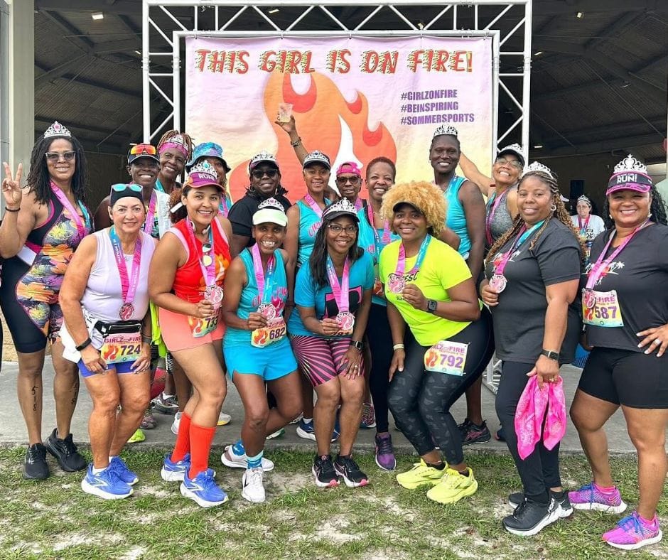A group of women huddled up taking a picture with their metals