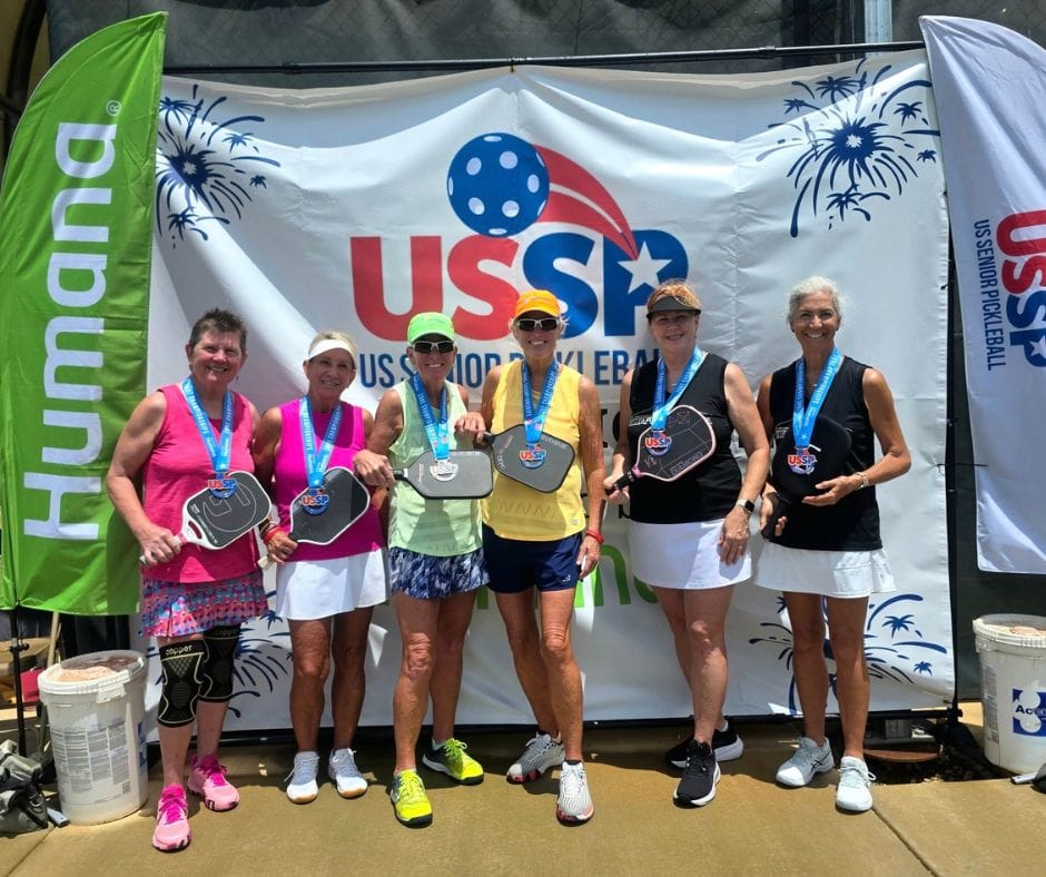 A group of people taking a picture with their medals